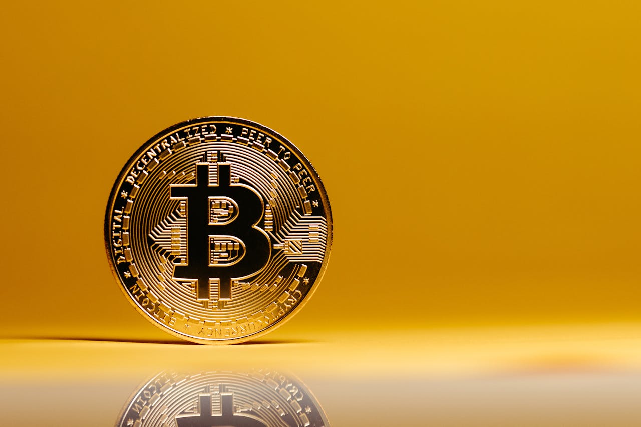 our-services-2 A shining Bitcoin coin placed on a reflective surface against a vibrant yellow background. Ideal for digital currency themes.